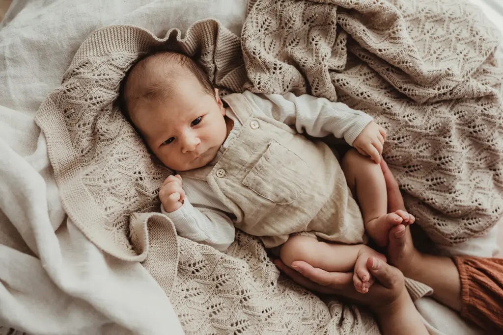 Newborn baby laying on cream knitted blanket – photographed in Warrnambool posed safely
