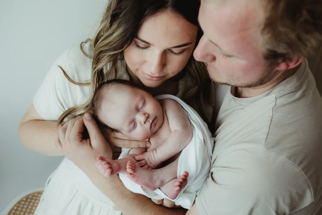 Warrnambool photographer with new parents and their newborn baby girl sleeping peacefully